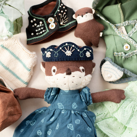 closeup of clara otter wearing riverbank dress for dolls with the rest of her collection
