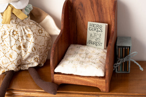 closeup of mini book Hero Girls of the Forest on wooden reading chair
